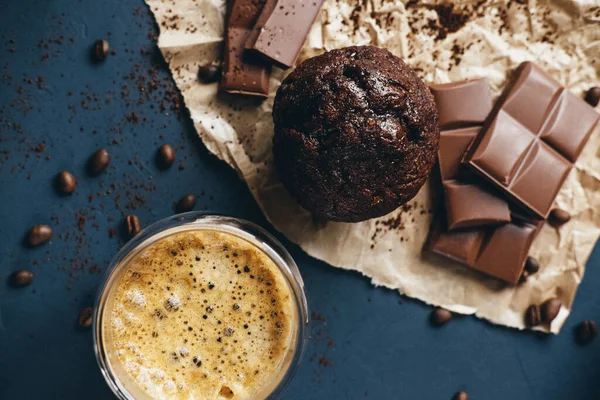 Coffee, muffin, chocolate on paper kraft on plaster background