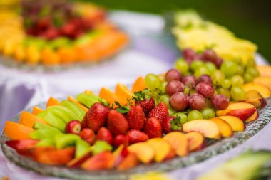 Açık büfe masada meyve kanepesi ikram eder.