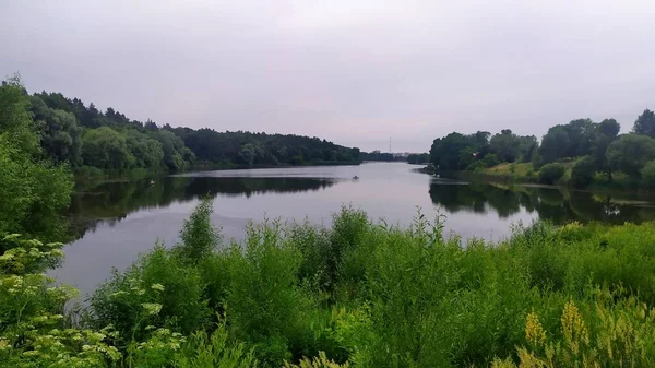 Tepeler arasında geniş bir nehir esiyor.