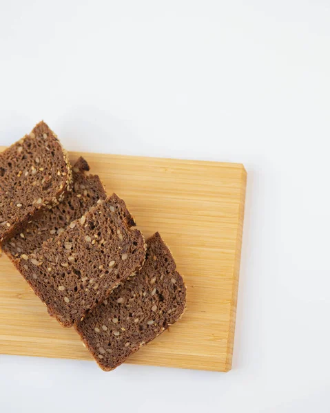 Beyaz tabakta siyah ekmek dilimi ve ahşap tahta