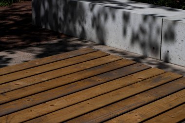 Bulanık arka planda ahşap yüzey. 3 boyutlu arka plan, ahşap podyum. Doğal ahşap boru seti. Ağaç yaprakları ve gölgeli doğa yeşili. Güzellik kozmetik ürünleri tanıtımı. Stüdyo minimal