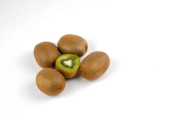 Olgun kivi meyvesi ve beyaz arka planda yarım kivi meyvesi.