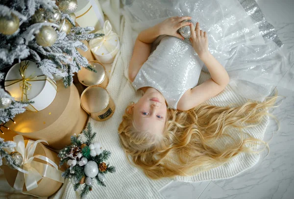 Okouzlující Malá Blondýnka Stříbrných Šatech Leží Blízkosti Vánočního Stromečku Horní Royalty Free Stock Obrázky