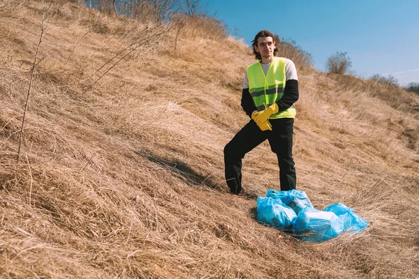 Hombre Activista Naturaleza Chaleco Amarillo Encuentra Cerca Bolsas Basura Azul —  Fotos de Stock