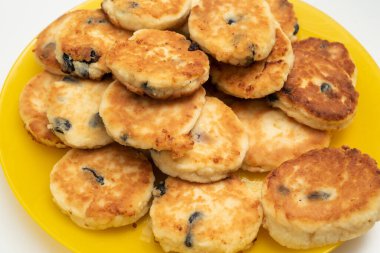 Beyaz arka planda tam sarı krep tabağı. Yakın plan fotoğrafı.