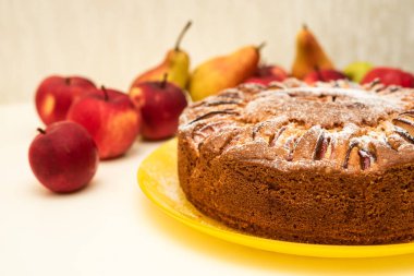 Charlotte elmalı turta evde pudra şekerli sarı tabakta elma ve armutla pişirildi.
