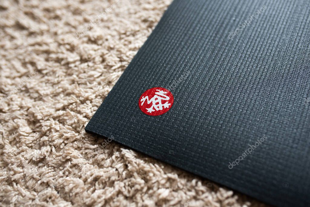 Manduka yoga mat company logo on the grey mat corner
