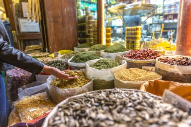 Doha, Katar 'da geleneksel bir sokak pazarından otlar ve baharatlar alan bir kadın.