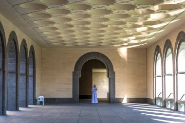 Doha, Katar - 2018, 18 Ocak - Tipik Orta Doğu kıyafetleri giymiş yerel bir muhafız Katar 'ın Doha kentindeki İslami Sanat Müzesi' nde kapanıyor