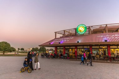 Doha, Qatar - 2018, January 19th - people enjoying an open air park in a late sunset in the suburbs of Doha, Qatar