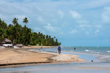 Brazil, Alagoas, 2021, january 21st - A long beach with tourists enjoying a summer day in northeast Brazil