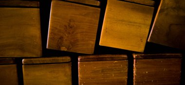 Odanın köşesine istiflenmiş kahverengi tahta kutu.