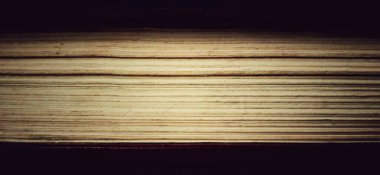 Geçmişi loş olan eski kitabın kâğıt sayfaları. Kütüphane, ofis, kampüs ve okul bilgileri için özel ve ticari reklamlar için uygundur.