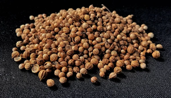 Dried coriander seed with negative space on the black background. Food ingredient background design. Suitable for the food advertising of company and industry, poster, backdrop, flyer, etc.