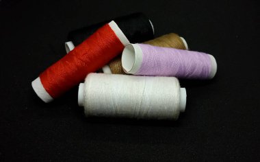 Makarna iplikleri. Makaraların farklı renklerinde dikiş ipliklerinin yakın plan çekimi, boş alan.