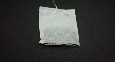 Siyah arkaplanda izole edilmiş tek bir çay poşeti.