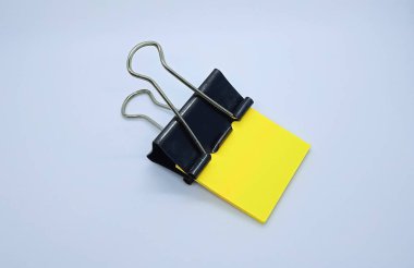 Siyah ataçlı sarı not kağıdı. Bağlayıcı ataç ve sarı not kağıdı yığını.