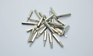 Değişken metal tornavida uçlarının farklı türleri, gri beyaz arka planda izole edilmiş..