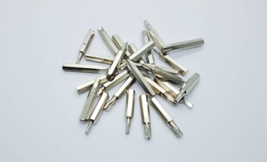 Değişken metal tornavida uçlarının farklı türleri, gri beyaz arka planda izole edilmiş..