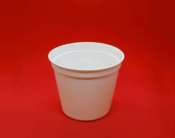 白色的小塑料罐 隔离在红色背景上 现实孤立的白色花盆 — 图库照片