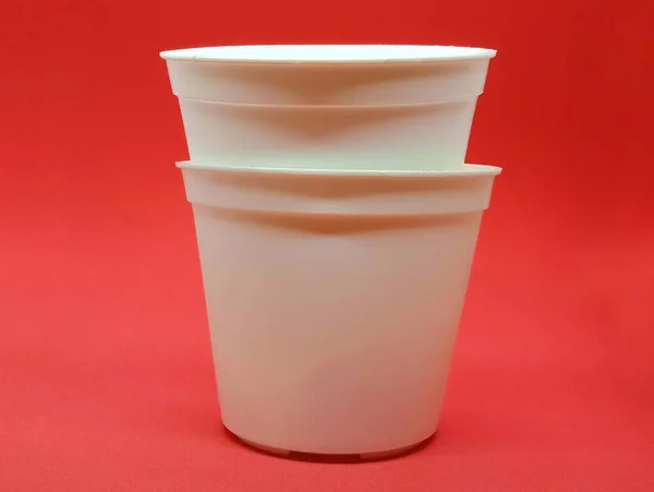 Pequeno Pote Plástico Branco Isolado Fundo Vermelho Pote Flor Branca — Fotografia de Stock