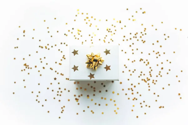 Gift white box with a gold tape with tinsel and confetti on a white background. The concept of a gift, a new year, a festive background — Stock Photo, Image