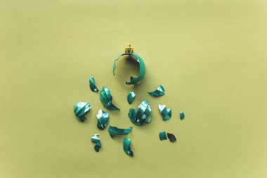 Kırık Noel oyuncağı topu yeşil arka planda az bir stilde. Başarısız yeni yıl kutlaması konsepti