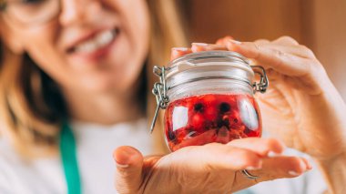 Meyve mayalanması. Elinde mayalanmış meyveli kavanoz tutan kadın..