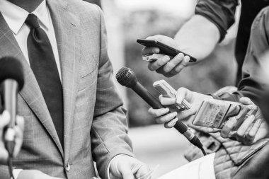 Medya Röportajı - mikrofonlu gazeteciler resmi giyinmiş politikacı veya işadamıyla röportaj yapıyorlar.