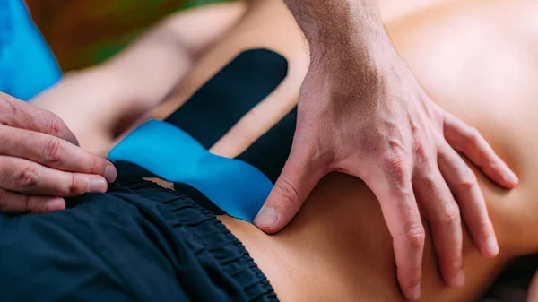 Aplicación Cinta Kinesio Fisioterapeuta Colocando Cinta Kinesio Espalda Baja Los — Foto de Stock