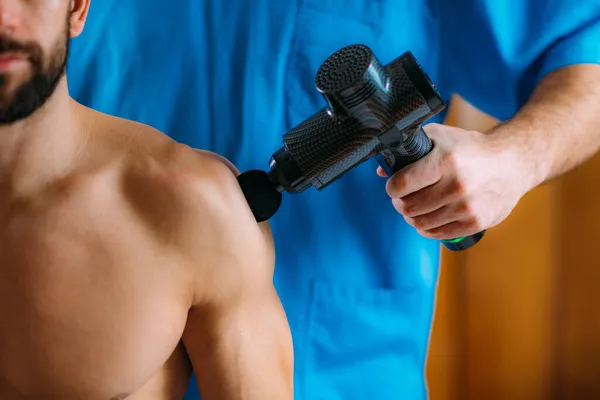 Terapeuta Tratamiento Lesiones Hombro Los Hombres Con Pistola Masaje —  Fotos de Stock