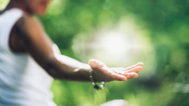 Pozitif kendini iyileştirme enerjisi geliştiriyorum. Kadın eli açık, ışıkla oynuyor, pozitif enerji yaratıyor.