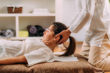 Kadın boynu geren terapist. Shiatsu masajı. 
