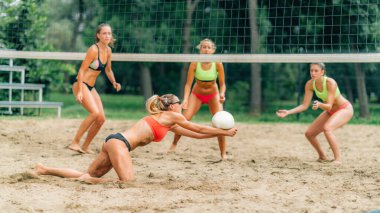 Plaj voleybolu oynayan genç kadınlar