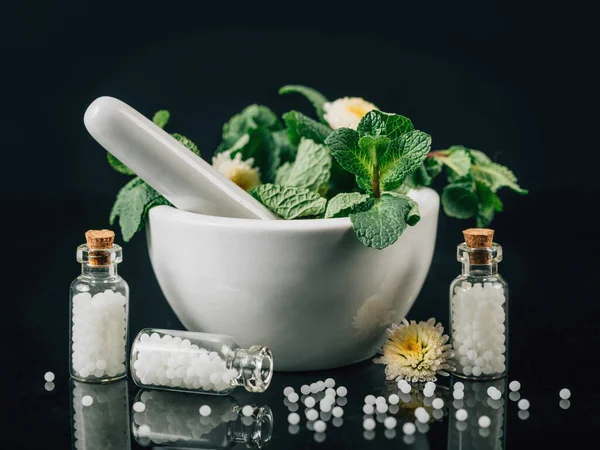 ホメオパシー治療 新鮮な薬用植物 黒の背景の完全なガラス瓶 モルタルや杵の散乱ホメオパシーの世界 — ストック写真