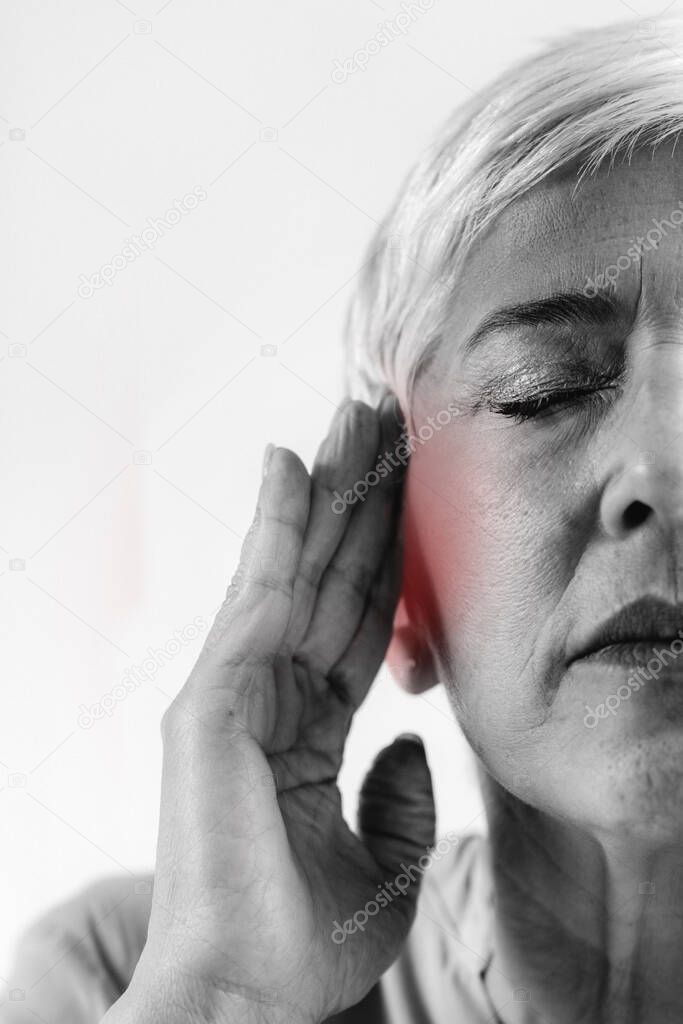 Tinnitus. Senior woman suffering from tinnitus.