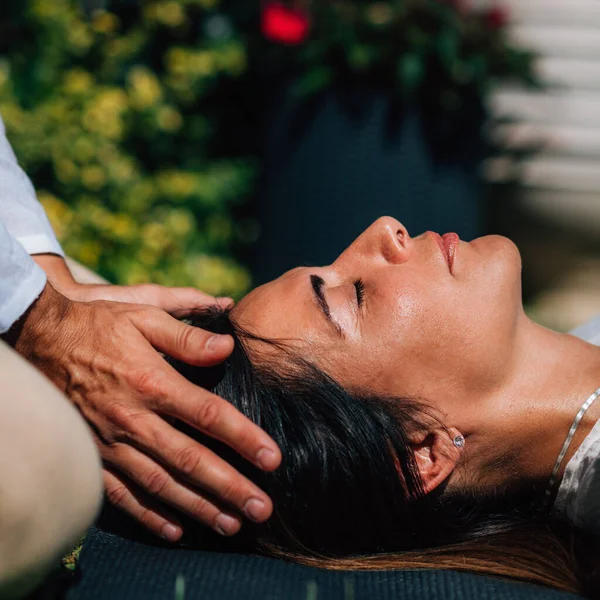 霊気治癒セッションの女性 心臓チャクラの上に手を取り エネルギーを転送レイキセラピスト 平和な女性は彼女の目を閉じて横になっている — ストック写真
