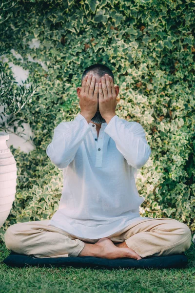目で座っていた男が目を閉じてレイキのセルフトリートメントをしていた 目に手を握る霊気修行者 — ストック写真
