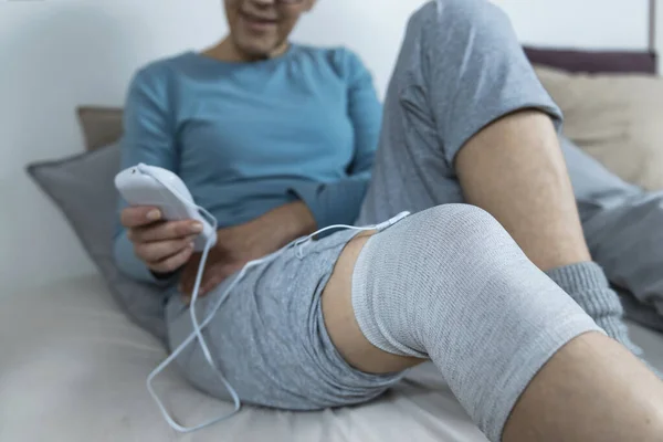 経皮的電気神経刺激 老人ホームで導電性の十電極靴下と膝の物理療法を行う — ストック写真