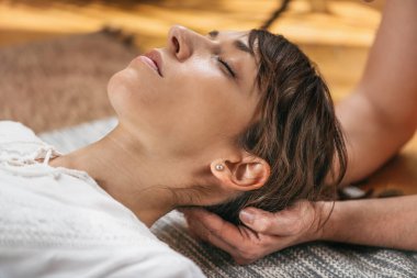 Geleneksel Tayland pasif boyun esnetme masajı. Pasif esneme geleneksel Tayland masaj tekniğinden hoşlanan genç bir kadın. 