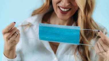 Gülümseyen kadın koruyucu maskesini çıkarıyor..