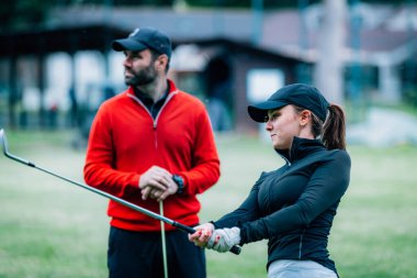 Golf hocası genç bir kadınla çalışıyor. Salıncak geliştirme üzerine.