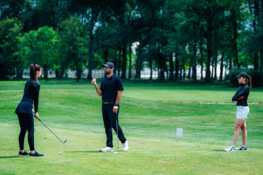 Golf oynuyordum. Golf hocasıyla golf oynayan genç bir kadın.