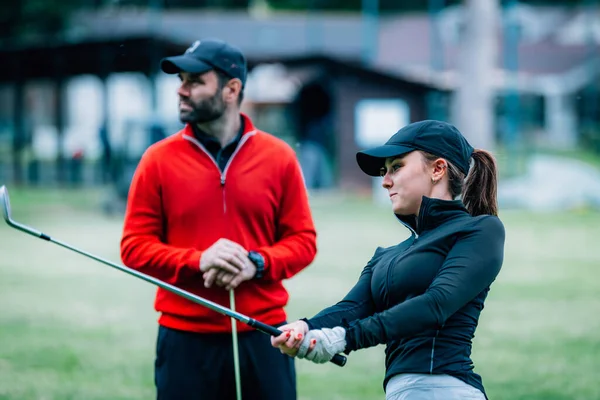 Golf hocası genç bir kadınla çalışıyor. Salıncak geliştirme üzerine.