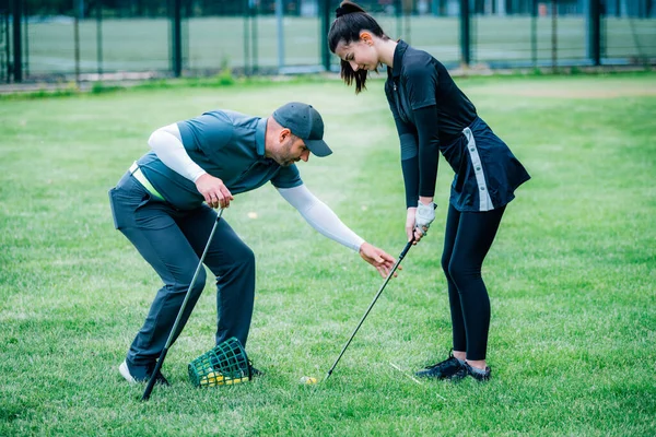 Bireysel golf dersi. Genç bir kadın golf hocasıyla golf dersi alıyor.