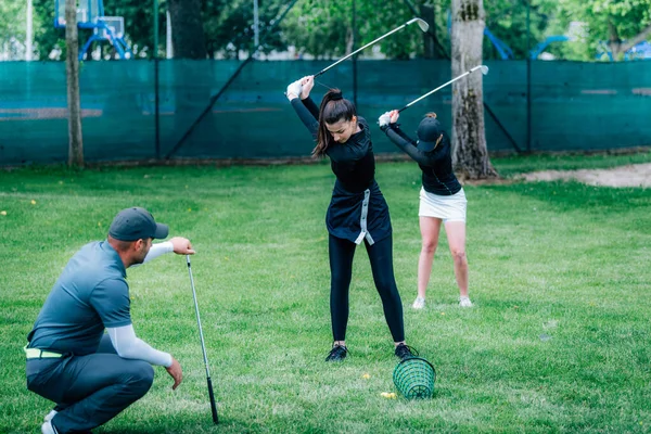 Golfschwungtechnik Golflehrer Arbeitet Mit Zwei Jungen Damen Auf Einem Golfplatz — Stockfoto
