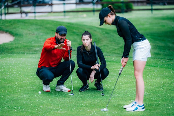 ゴルフのレッスン 2人の若い女性ゴルファーゴルフインストラクターと一緒に練習 — ストック写真