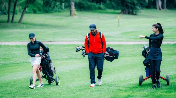 Golf antrenmanı. Golf hocasıyla golf dersi alan iki genç bayan.