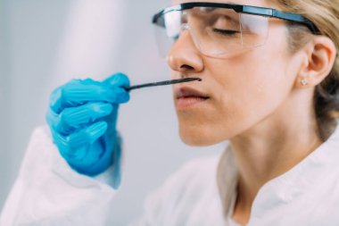 Olgunluk testi. Laboratuvarda vanilya kokusunu inceleyen kadın bilim adamı..