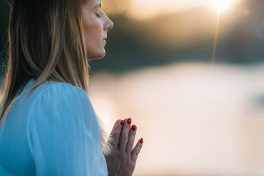 Göl kenarında meditasyon yapan kadın. Dua Konumu.  
